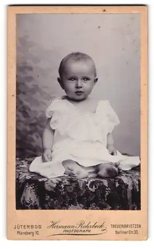 Fotografie Hermann Rohrbeck, Jüterbog, Planeberg 10, Süsses Kleinkind im Kleid mit nackigen Füssen