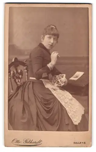 Fotografie Otto Gebhardt, Halle a. S., Poststr. 9-10, Junge Dame mit Kleid sitzt am Pult