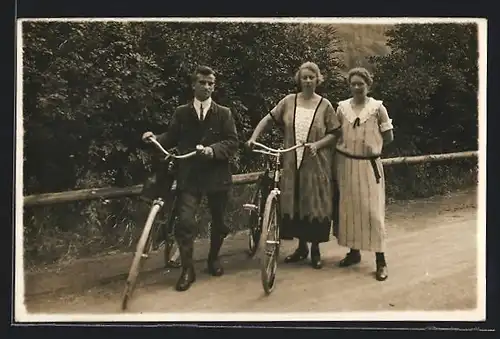 Foto-AK Zwei Frauen und ein Mann mit Fahrrädern