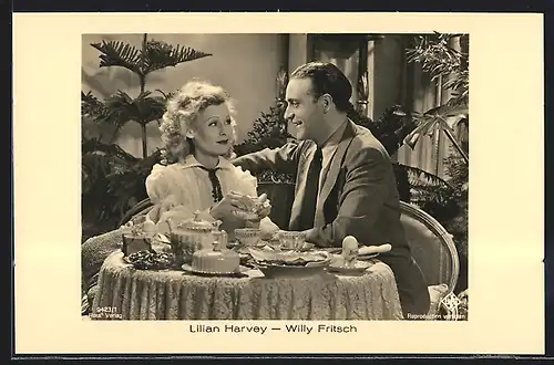 AK Schauspielerin Lilian Harvey und Schauspieler Willy Fritsch sitzen an einem Frühstückstisch