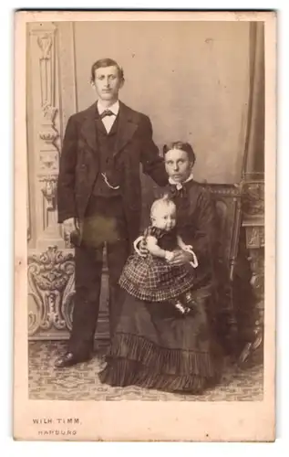 Fotografie Wilh. Timm, Harburg, Lindenstr. 7, Ehepaar posiert mit der kleinen Tochter der die Haare zu Berge stehen