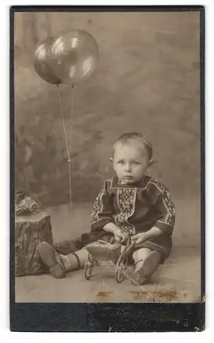 Fotografie O. Kneip, Bonn, niedliches Kleinkind mit Lehmann Tutu Blechauto an der Seit, Spiegelung im Ballon