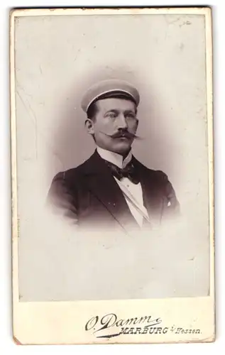 Fotografie O. Damm, Marburg i. Hessen, Student im Anzug mit Fliege und Couleur, Moustache