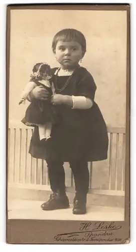 Fotografie H. Leske, Spandau, Portrait junges Mädchen im Kleid hält ihre Puppe ganz fest an sich gedrückt