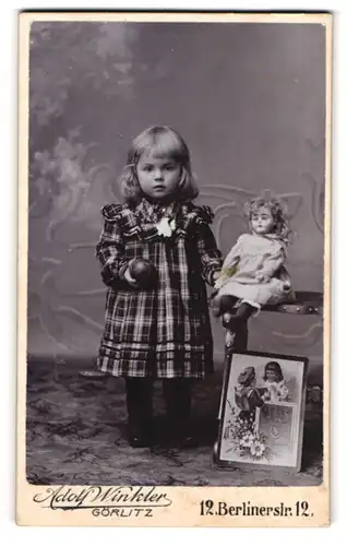 Fotografie Adolf Winkler, Görlitz, süsses Mädchen im karierten Kleid mit ihrer Puppe auf dem Stuhl
