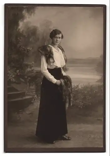 Fotografie A. Kulhanek, Berlin, junge Frau in weisser Bluse und schwarzem Rock mit Pelzüberwurf und Muff
