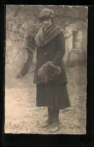 AK Gutaussehende Dame mit Pelzkragen und Muff beim Spaziergang