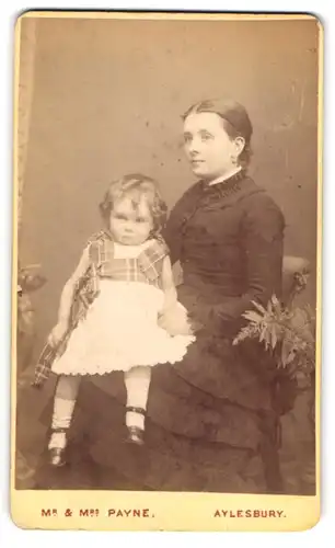 Fotografie Mr. & Mrs. Payne, Aylesbury, junge englische Mutter mit ihrer kleinen Tochter auf dem Schoss, Mutterglück
