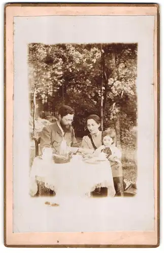 Fotografie unbekannter Fotograf und Ort, Mutter und Vater beim Kaffe mit Tochter auf dem Schoss, Mutterglück, 1894