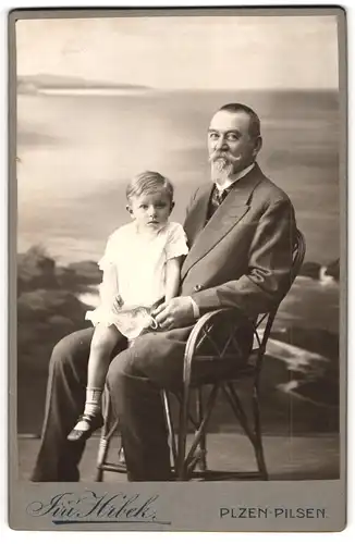 Fotografie Jiri Hrbek, Pilsen, Vater im Anzug mit seinem Sohn auf dem Schoss