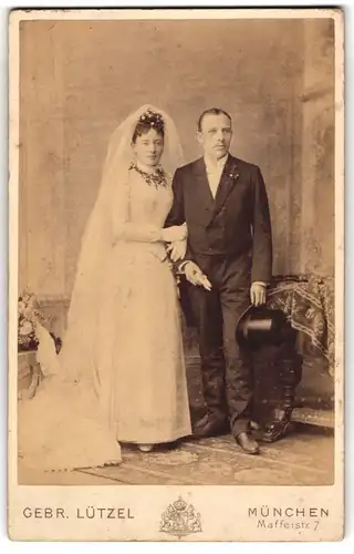 Fotografie Gebr. Lützel, München, Ehepaar im weissen Brautkleid und im Anzug mit Zylinder