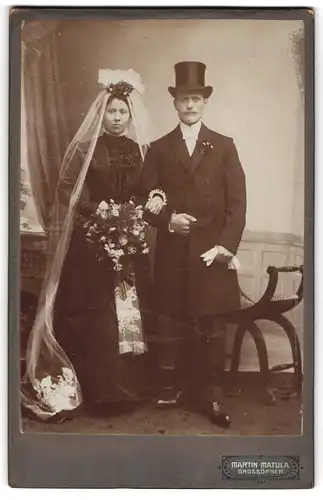 Fotografie Martin Matula, Grossörner, Ehepaar im schwarzen Brautkleid und im Anzug mit Zylinder auf dem Kopf