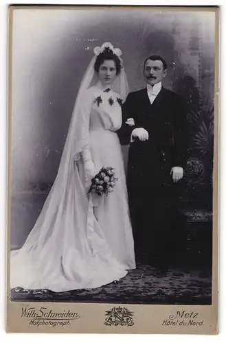 Fotografie Wilh. Schneider, Metz, junges Brautpaar im weissen Hochzeitskleid und im Anzug mit Chapeau Claque