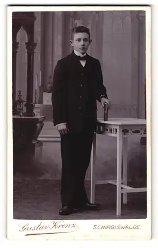 Fotografie Gustav Krenz, Schirgiswalde, Portrait junger Mann im Anzug mit Fliege und Buch
