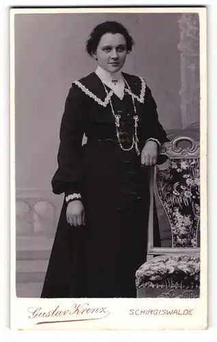 Fotografie Gustav Krenz, Schirgiswalde, Portrait junge Dame im modischen Kleid an Stuhl gelehnt