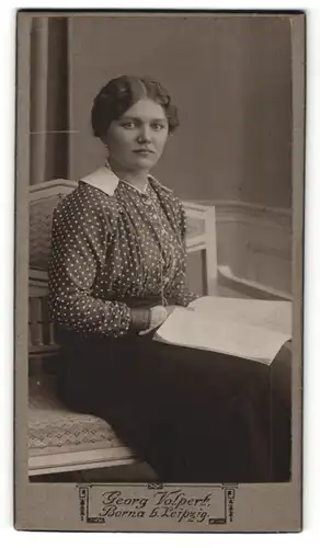Fotografie Georg Volpert, Borna, Frau in gepunkteter Bluse mit lockigen Haaren und Buch in den Händen