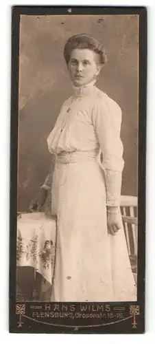 Fotografie Hans Wilms, Flensburg, Frau in hellem Kleid und hochgesteckter Frisur stehend