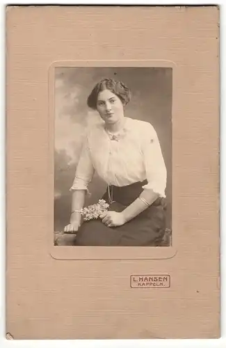 Fotografie L. Hansen, Kappeln, Frau in Bluse und Rock mit Scheitelfrisur und Blumen in den Händen sitzend