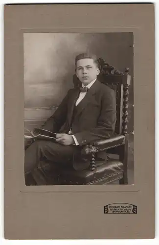 Fotografie Richard Krasselt, Borna, Portrait sitzender Herr im Anzug mit Fliege und Zeitung