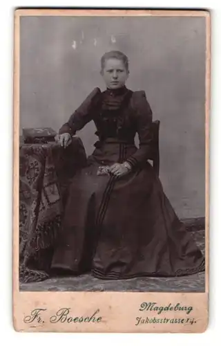 Fotografie Fr. Boesche, Magdeburg, junge Frau sitzend in schwarzem Kleid
