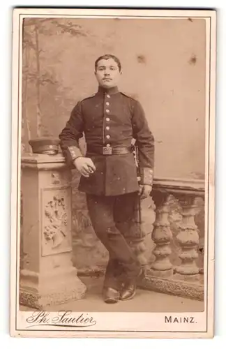 Fotografie Ph. Sautier, Mainz, Portrait Soldat in Uniform mit Zigarre an Sockel gelehnt