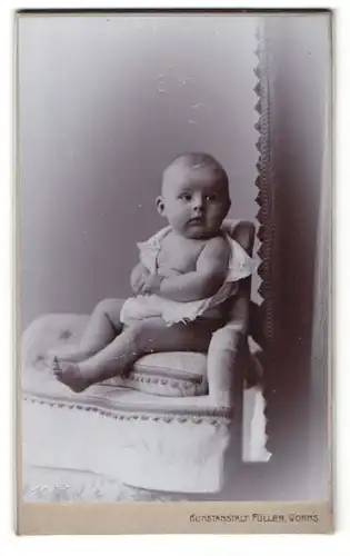 Fotografie Aug. Füller, Worms am Rhein, Portrait niedliches Kleinkind im weissen Hemd auf Kissen sitzend