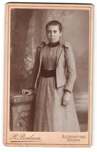 Fotografie R. Bodmer, Altstaetten, Portrait junge Dame in modischer Kleidung an Sockel gelehnt