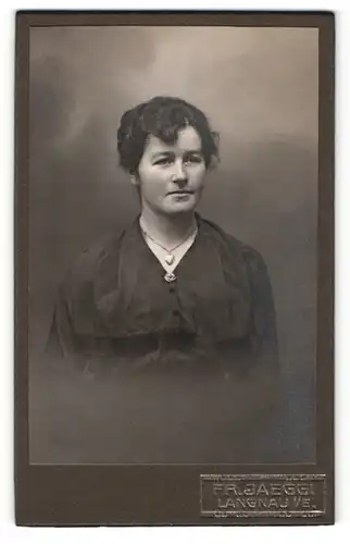Fotografie Fr. Jaeggi, Langnau i / E., Portrait junge Dame im schwarzen Kleid mit Herzkette