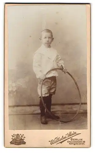 Fotografie Wilhelm Stein, Berlin, Chausseestr. 66, Hübscher Junge mit kurzen Hosen und Hula-Hoop Reifen