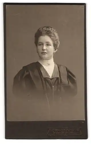 Fotografie Hermann Schlüter, Magdeburg, Gutaussehende junge Frau im schwarzen Kleid mit Perlenohrringen