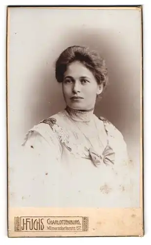 Fotografie J. Fuchs, Charlottenburg, Wilmersdorfer Str. 57, Hübsche Dame im hochgeschlossenen Kleid mit Schleife