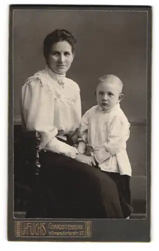 Fotografie J. Fuchs, Charlottenburg, Wilmersdorfer Str. 57, Brünette Dame mit weisser Bluse posiert mit süssem Jungen