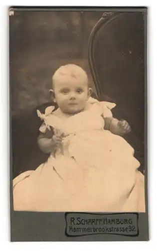 Fotografie R. Scharff, Hamburg, Hammerbrookstr. 32, Niedliches Baby in weissem Kleid mit Schleifen und grossen Ohren