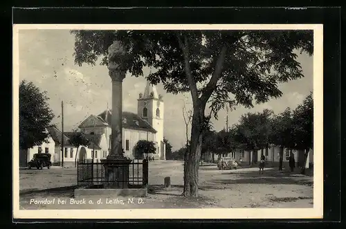 AK Parndorf b. Bruck a. d. Leitha, Ortspartie mit Denkmal und im Hintergrund die Kirche