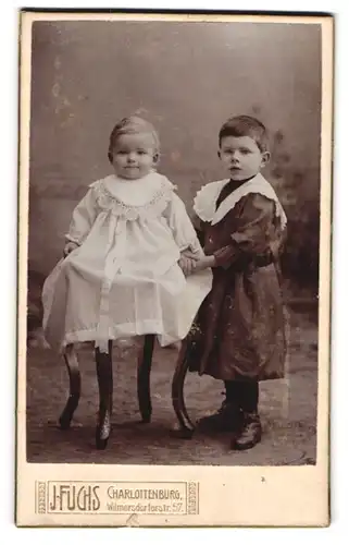 Fotografie J. Fuchs, Charlottenburg, Wilmersdorferstr. 57, Kind im Kleid mit einem Geschwisterchen