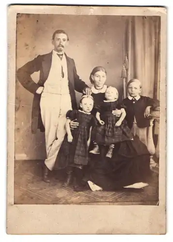 Fotografie unbekannter Fotograf und Ort, Mutter und Vater mit ihren drei Kindern im Atelier