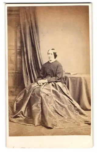 Fotografie H. J. Whitlock, Birmingham, englische Dame im weiten Kleid posiert sitzend im Atelier