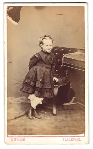 Fotografie E. Brook, Blackpool, niedliches kleines englisches Mädchen im dunklen Kleid mit Locken