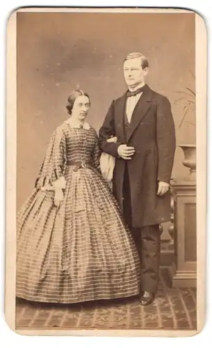 Fotografie C. Reiner-Rocksch, Dresden, älteres sächsiches Paar im karierten Kleid und im Anzug, Arm in Arm