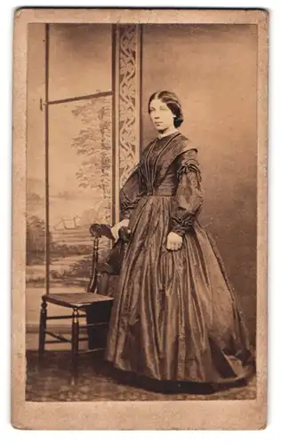 Fotografie unbekannter Fotograf und Ort, Portrait junge Dame im seidenen Kleid vor einer Studiokulisse