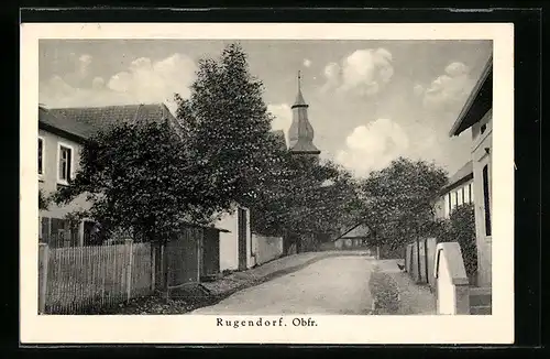 AK Rugendorf /Obfr., Strasse zwischen Wohnhäusern und mit Blick auf den Kirchturm