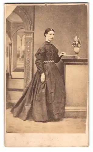 Fotografie H. Mower, Exeter, junge Engländerin im dunklen Kleid mit Brosche, Studiokulisse