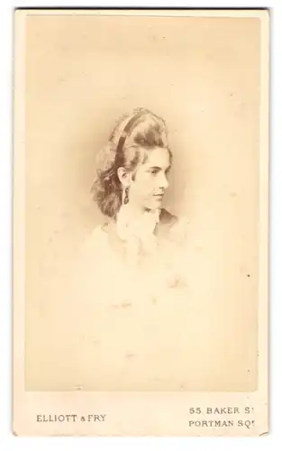 Fotografie Elliott & Fry, London, junge Frau mit toupierten Haaren und Ohrringen