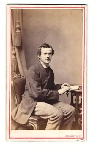 Fotografie Helsby & Co., Liverpool, junger Engländer im Tweed Anzug sitzend am Tisch