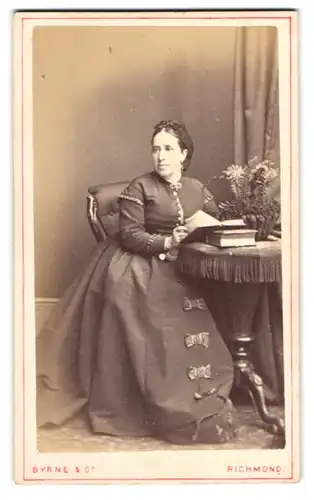 Fotografie Byrne & Co., Richmond, Dame im dunklen Kleid mit Schleifen besetzt