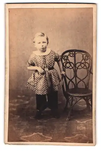 Fotografie unbekannter Fotograf und Ort, niedliches kleines Kind im karierten Kleid