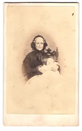 Fotografie J. Mitchell, Truro, Grossmutter im dunklen Kleid mit ihrem Enkelkind im Arm