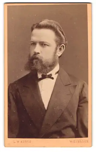 Fotografie L. W. Kurtz, Wiesbaden, Herr im Anzug mit Fliege und Vollbart, 1877