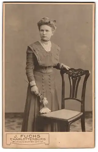 Fotografie J. Fuchs, Charlottenburg, Wilmersdorfer Str. 57, Junge Dame im Kleid mit Blume