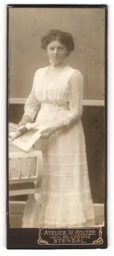 Fotografie W. Koltze, Stendal, Portrait junge Dame im weissen Kleid mit Zeitung in der Hand